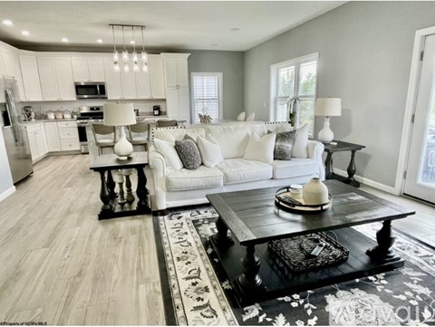 A modern living room with a black coffee table and a white sofa.