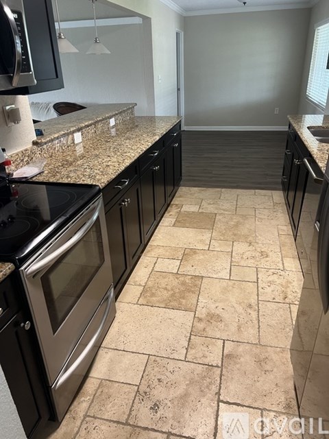 A kitchen with black appliances and a granite countertop.