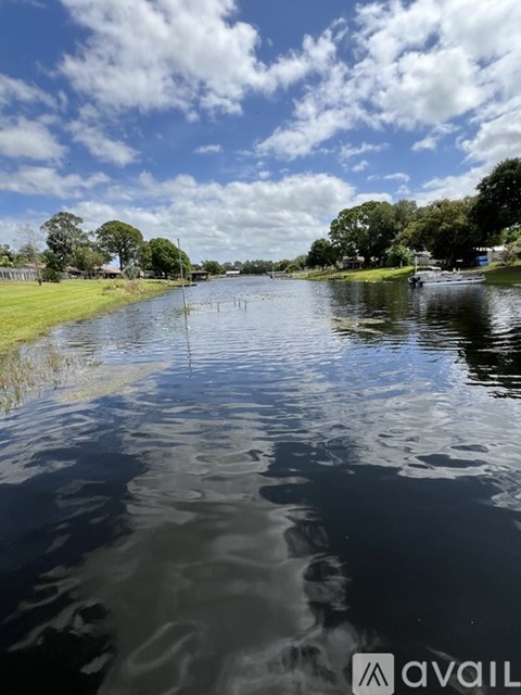A calm river with trees on the side and a clear sky.