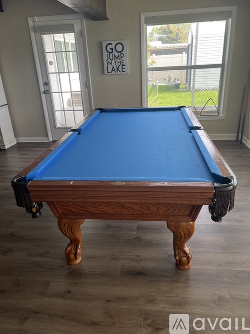 A pool table in a room with a sign that says "GO JUMP IN THE LAKE".