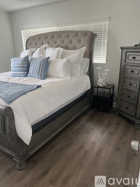 A bedroom with a bed, nightstand, and dresser.