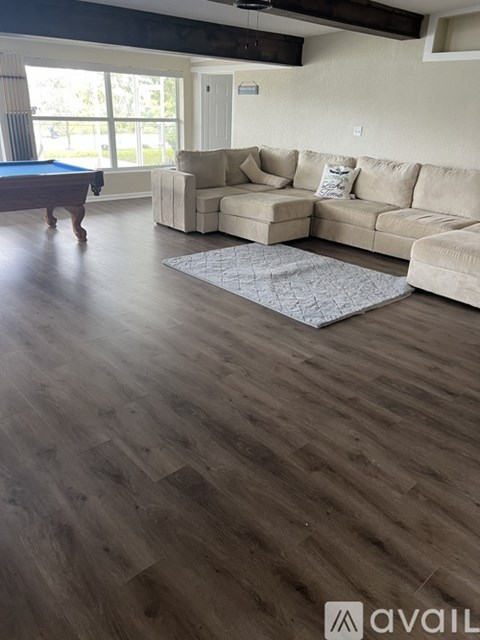 A living room with a pool table and a couch.