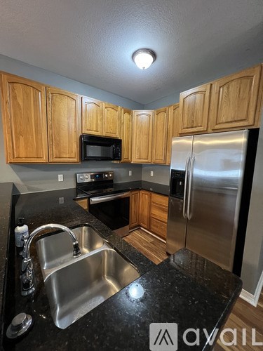 A kitchen with wooden cabinets and a black countertop.