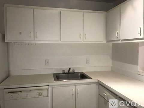 A kitchen with white cabinets and appliances.