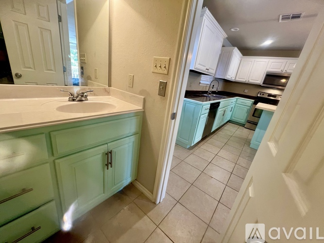 A kitchen with white cabinets and a sink.