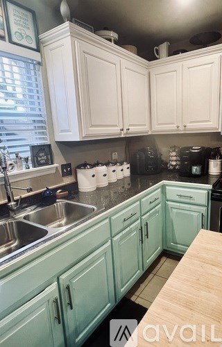 A kitchen with white cabinets and a sink.