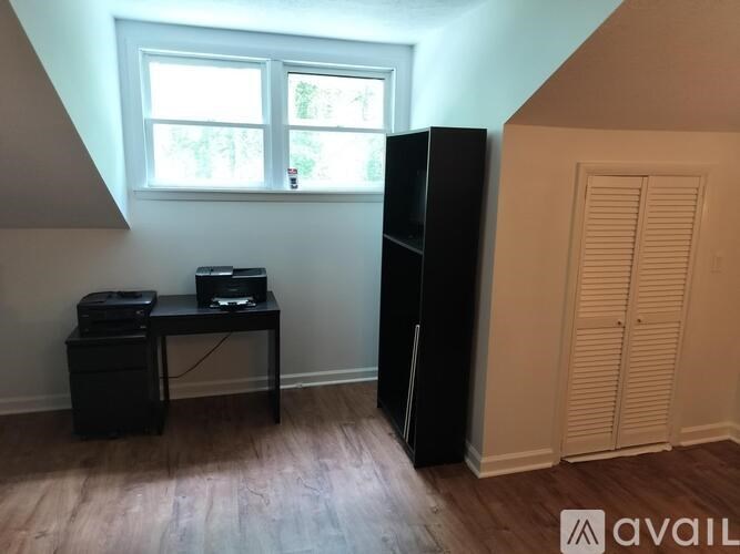 A room with a desk, printer, and a tall cabinet.