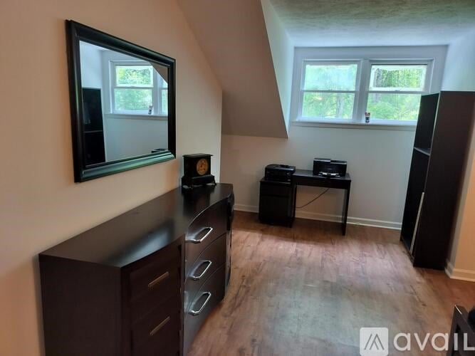 A room with a mirror, a desk, and a cabinet.