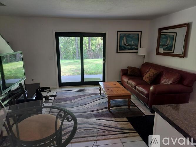 A living room with a couch, chair, and sliding glass doors.