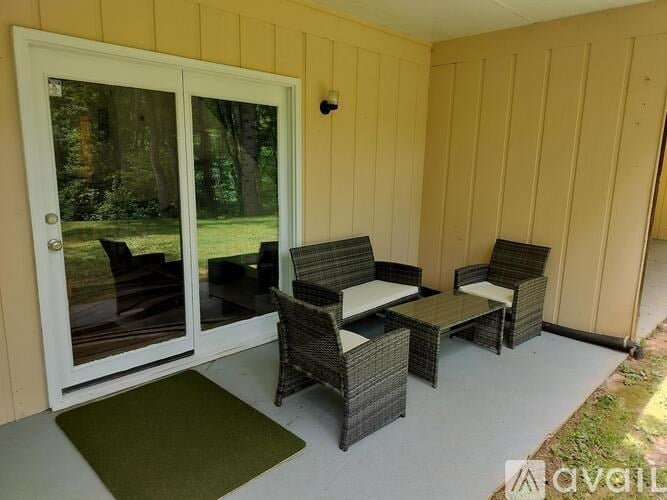 A patio with a table and chairs and a sliding glass door.