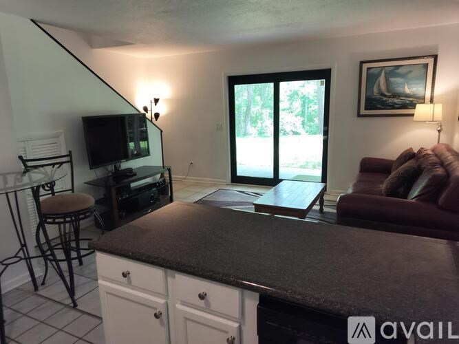 A living room with a couch, a television, and a painting on the wall.