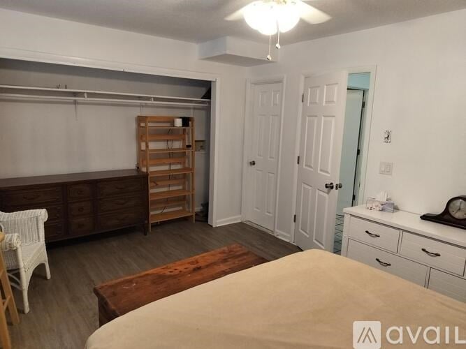 A bedroom with a bed, dresser, and a wooden cabinet.