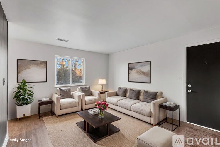 A living room with a couch, a coffee table, and a potted plant.