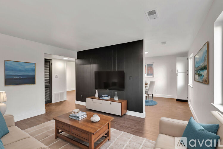 A living room with a wooden coffee table and a flat screen TV.