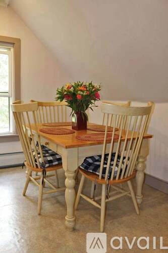 A table with chairs and flowers on it.