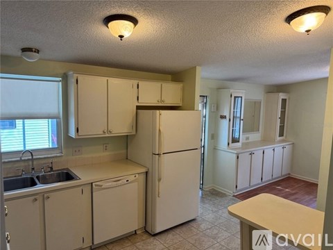A kitchen with white appliances and cabinets.