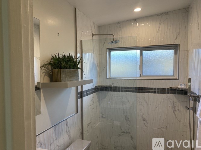 A bathroom with a marble wall and a window.