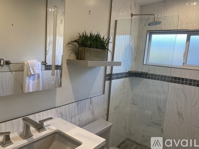 A bathroom with a marble sink and a glass shower.