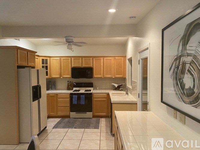 A kitchen with wooden cabinets and a refrigerator.