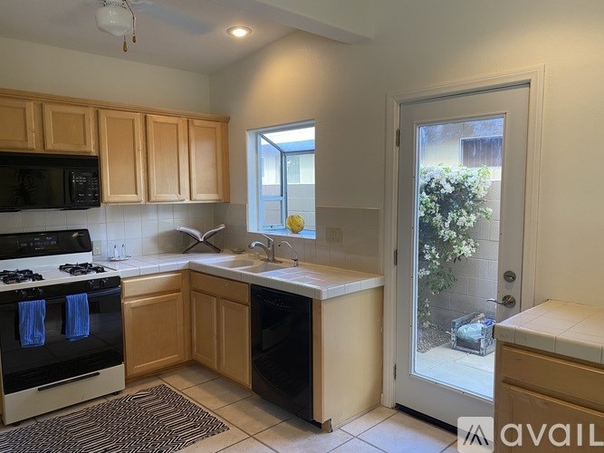 A kitchen with wooden cabinets and a black stove top oven.
