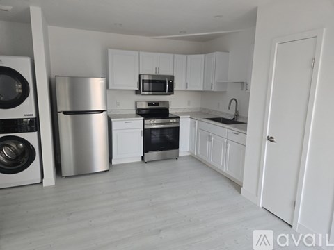 A modern kitchen with white cabinets and stainless steel appliances.