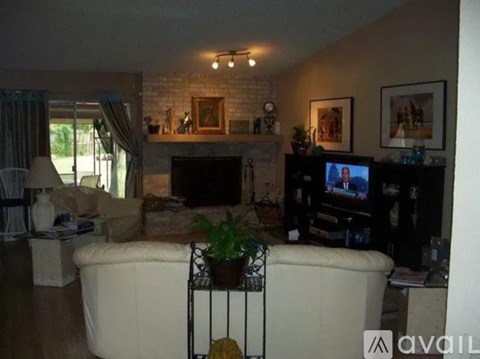 A living room with a white couch and a fireplace.