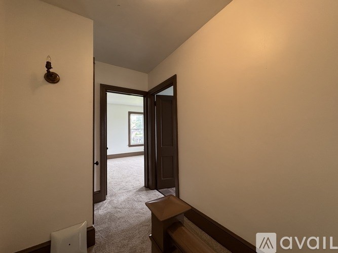 A hallway with a door leading to another room.