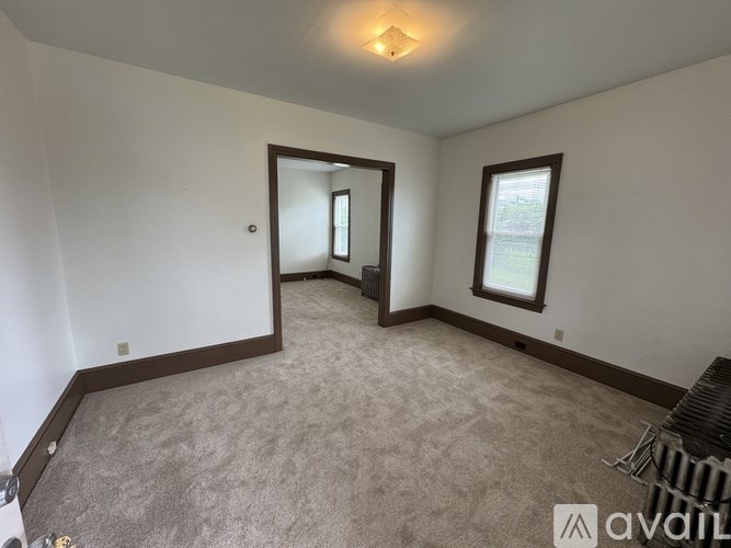 A room with a carpeted floor and a mirror on the wall.
