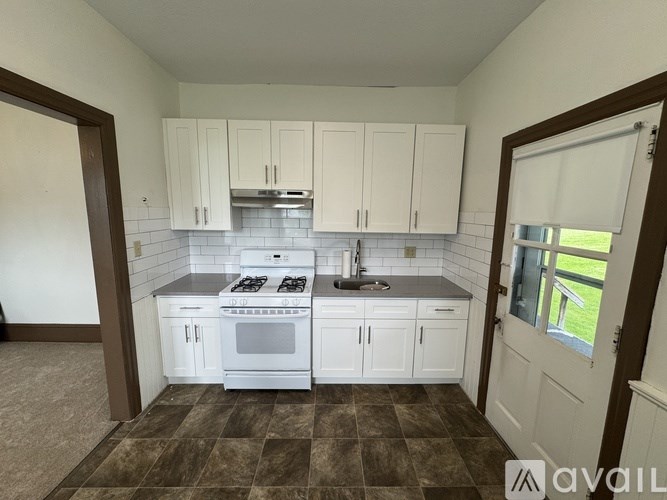 A kitchen with white cabinets and a checkered floor.