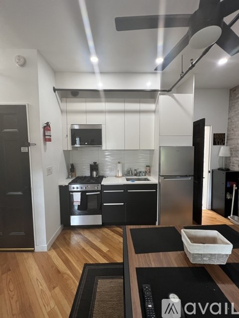 A kitchen with black cabinets and stainless steel appliances.