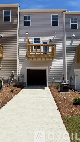 A two-story apartment building with a garage and a balcony.