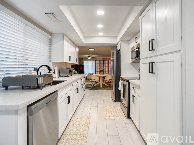 A spacious room with wooden flooring and a door leading to another room.