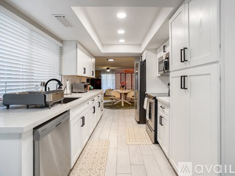 A spacious room with wooden flooring and a door leading to another room.