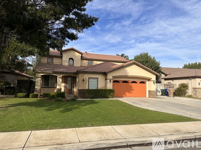 A house with a brown roof and a red garage door.