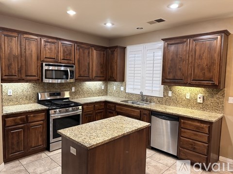 A kitchen with wooden cabinets and granite countertops.