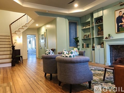 A living room with a grey sofa and a wooden staircase.