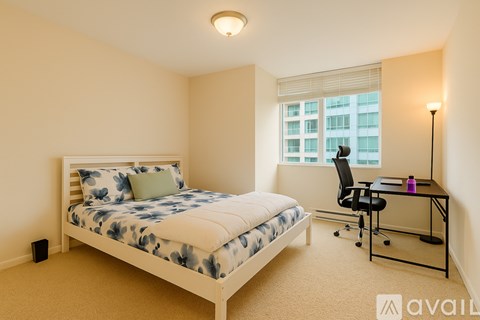 A bedroom with a bed, desk, and chair.
