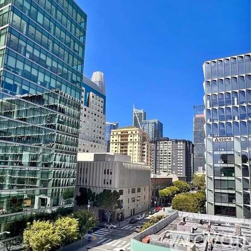 A cityscape with tall buildings and a clear blue sky.