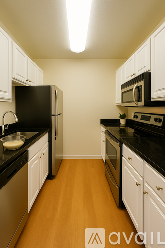 A kitchen with black appliances and white cabinets.
