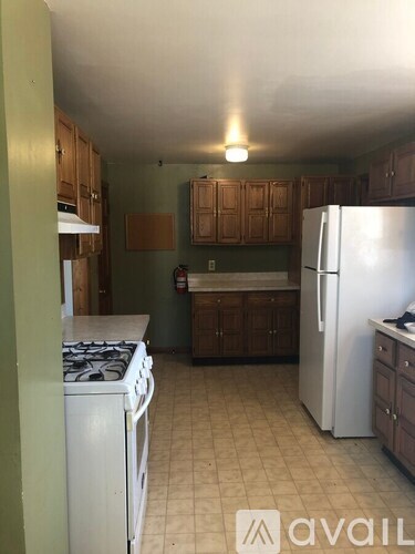 A kitchen with a white refrigerator and a stove top oven.