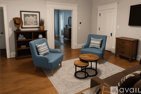 Two blue chairs with striped pillows are in a living room.