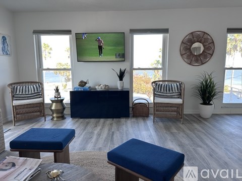 A living room with a blue sofa and a television playing baseball.