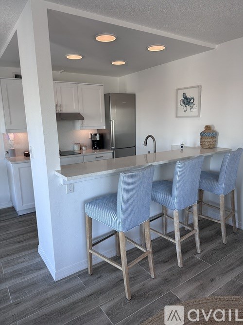 A kitchen with a bar and four chairs.