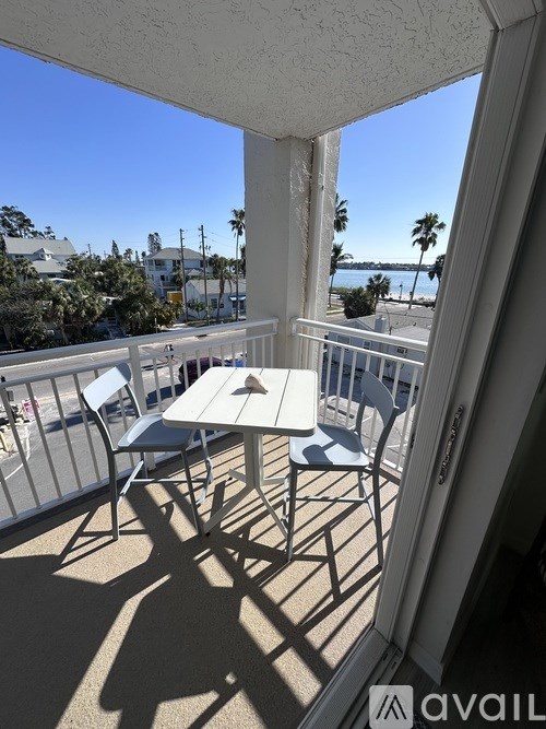 A balcony with a table and chairs overlooking the street.