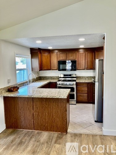 A kitchen with wooden cabinets and a granite countertop.