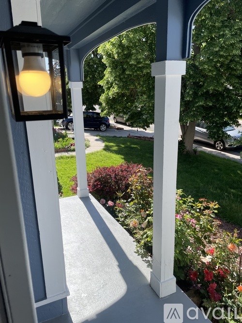 A porch with a light on and a view of the street.