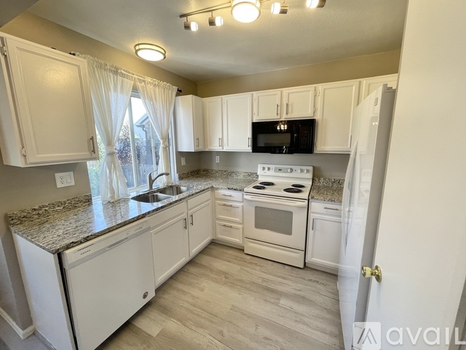 A kitchen with white cabinets and a granite countertop.