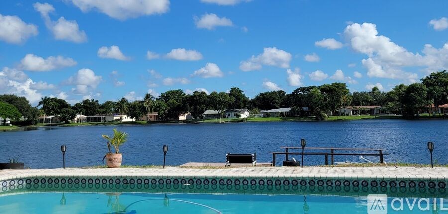 A pool with a view of a lake and trees.