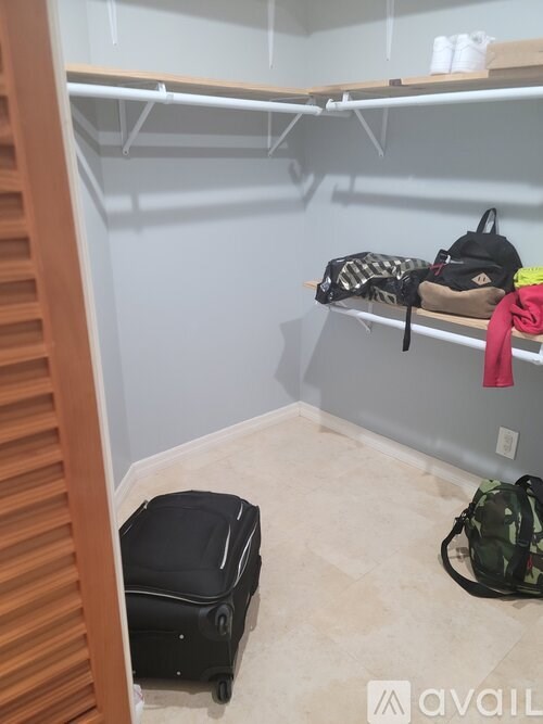 A room with a luggage bag and a backpack on the floor.