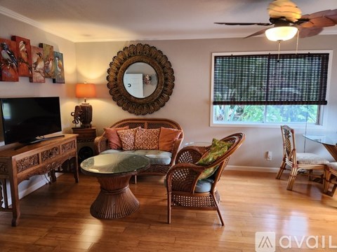 A living room with a glass table and a mirror on the wall.
